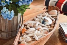 a boat filled with seashells and starfish is a nice decoration for any seaside space
