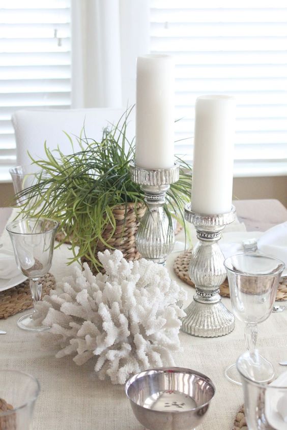 a coastal centerpiece of corals, grasses, candles in lovely candleholders is a very chic and cool idea to rock