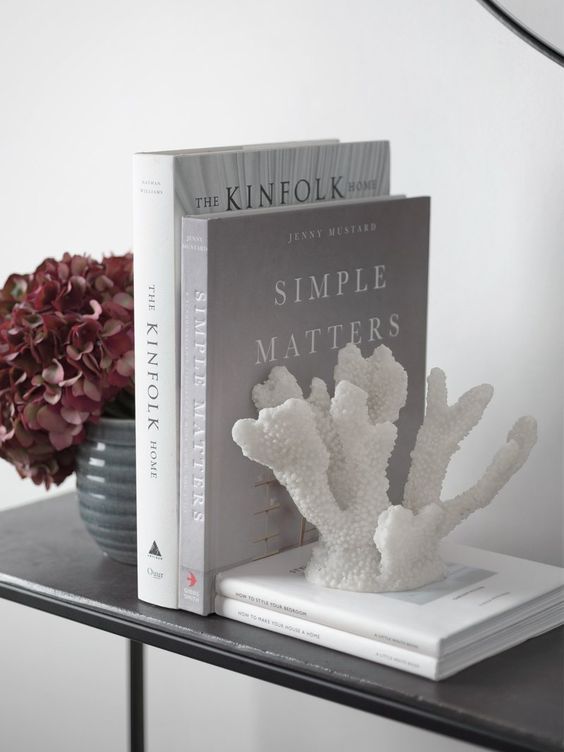 a faux coral as a book end is a lovely idea to slightly give a coastal feel to your home, a very stylish and cool way