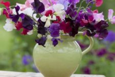 a green milkpot with bright florals is a nice rustic-style centerpiece or decoration for your summer space