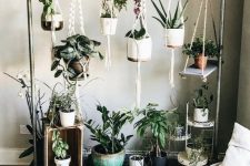 a metal and wood stand with lots of hanging planters with flowers and succulents is a very stylish idea