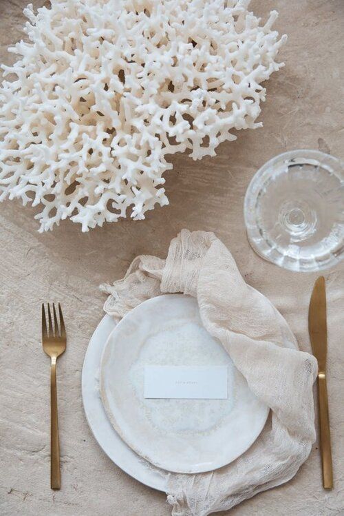 a neutral tablescape with a coral centerpiece feels coastal and beachy at once and looks very pretty