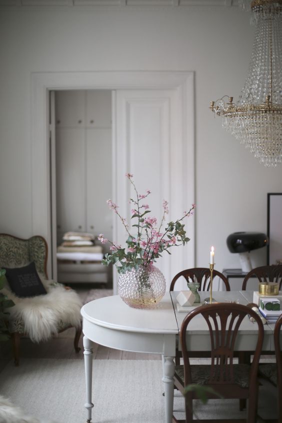 a refined patterned glass vase with pink flowers and a matching crystal chandelier for an exquisite feel