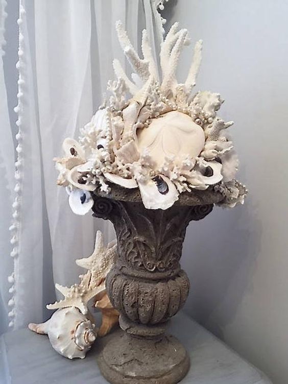a vintage urn with seashells, corals and other stuff is a lovely idea for a seaside space, an outdoor or an indoor one