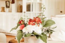 a white metal bucket with red and white blooms and oversized leaves for a simple and cool summer bouquet