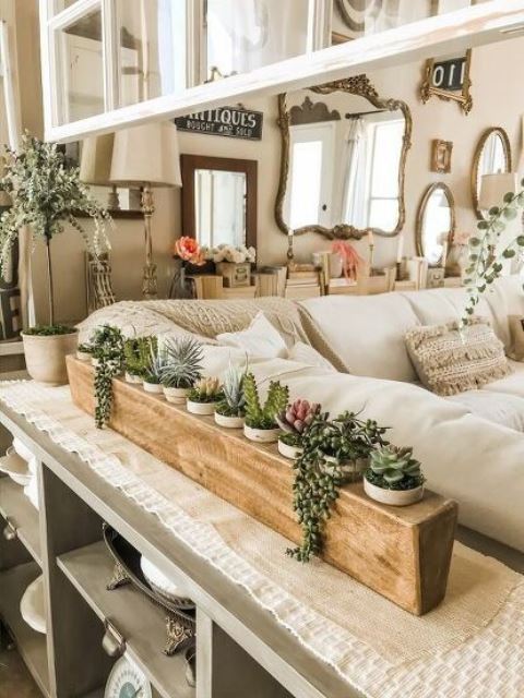 a wooden stand with plenty of planters and succulents of various kinds is a stylish idea for a console table