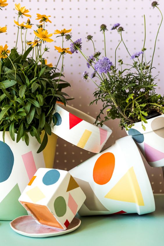 an arrangement of colorful print pots attached to each other and with bright summer blooms is lovely