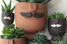 quirky terracotta and black planters with moustaches and succulents are a fun and bold idea to rock