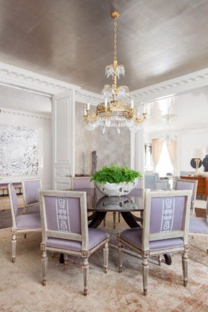 a beautiful metallic ceiling, a round table and lilac chairs create a lovely look, and a gold crystal chandelier adds to it