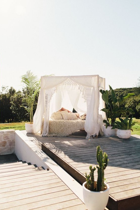 a boho styled outdoor bedroom under a canopy may be enough to relax and to protect you from the sun