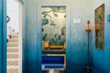 a bold and unique entryway with ombre blue walls, a bold floor with geo stencils and a small niche with a daybed