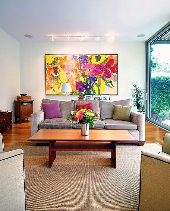 a bold floral artwork, bold blooms in a vase and colorful pillows to make your living room extra bold