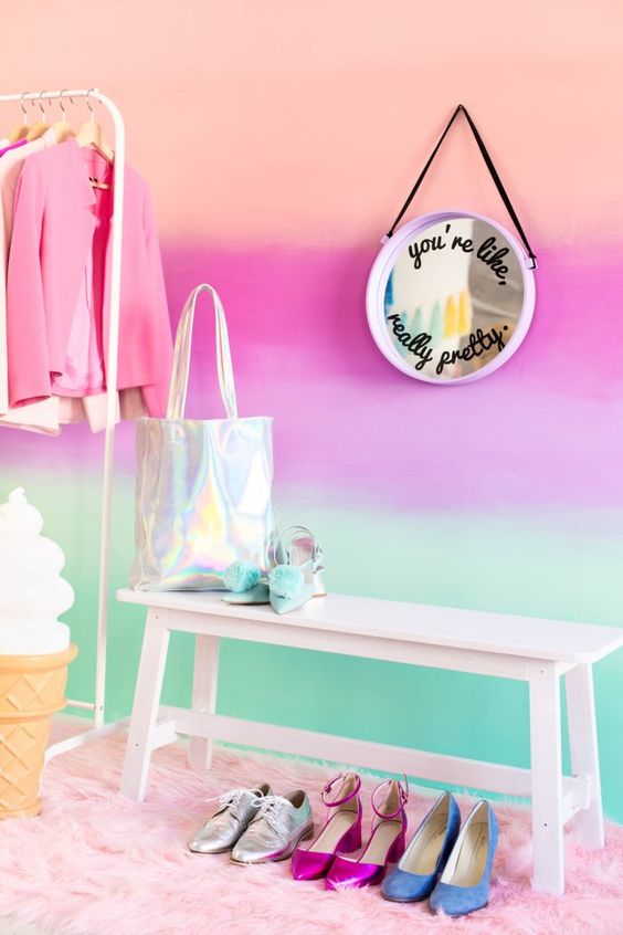 a bold gradient wall from peachy to hot pink and neon green, with a white bench and a round mirror is a fun and cool idea