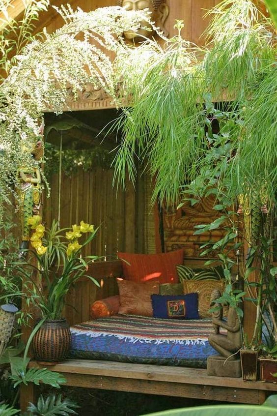a bright boho bedroom in a cabana, with lots of colorful pillows and greenery and blooms around