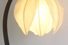 a curved table lamp with a flower-shaped lampshade looks very pretty and very chic