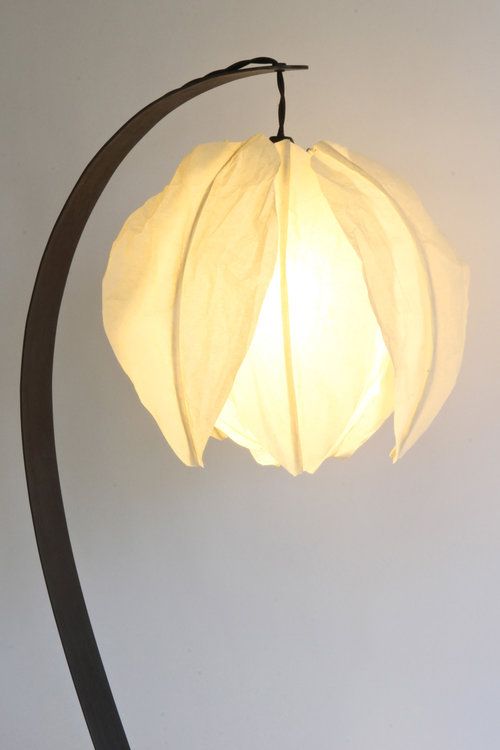 a curved table lamp with a flower-shaped lampshade looks very pretty and very chic