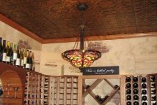 a home wine cellar spruced up with a pressed tin ceiling that gives a chic and vintage feel to the space