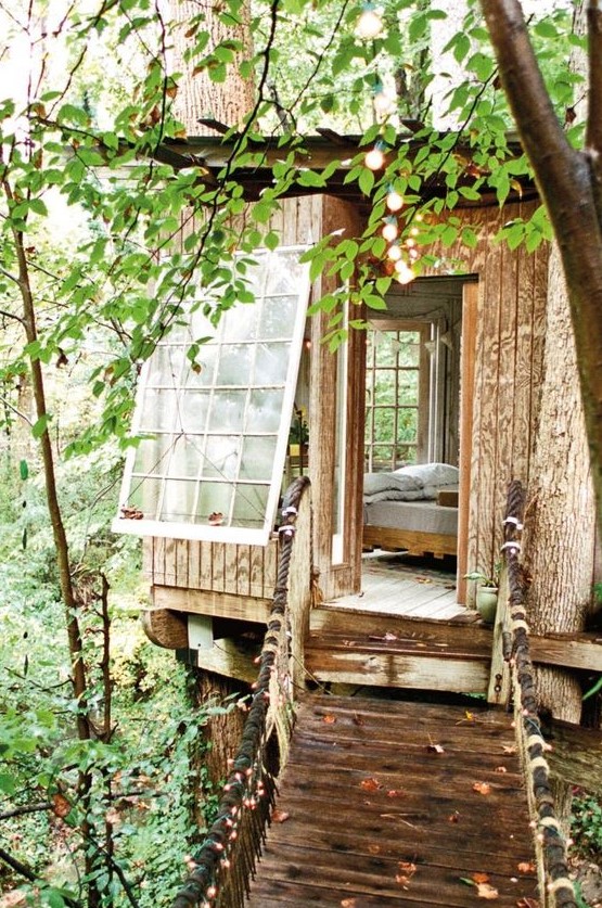 a large tree house with large windows and a bed inside is a perfect spot to escape to and relax a little bit
