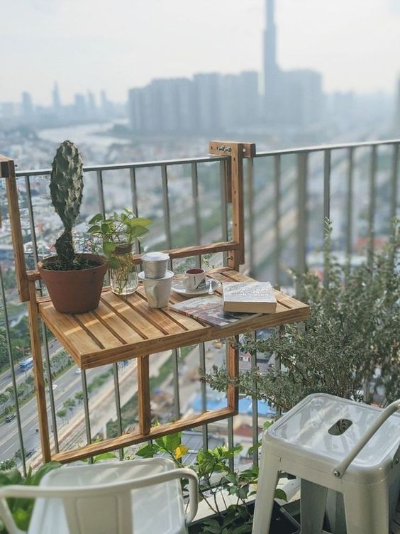 a little wooden folding table that can be hung on the railing is a brialliant idea for a tiny or small balcony and it looks eco friendly and natural