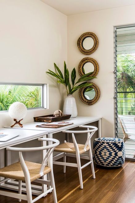 a lovely beach home office in neutrals, with a shared desk, woven chairs, mirrors wrapped with rope and a tiny window