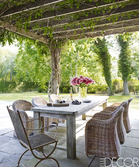 a modern farmhouse dining space with a reclaimed wood and concrete table, wicker chairs and a meta one plus blooms