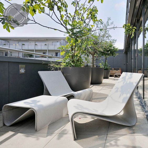 a modern terrace done with catchy concrete furniture and potted trees is a lovely space to enjoy fresh air