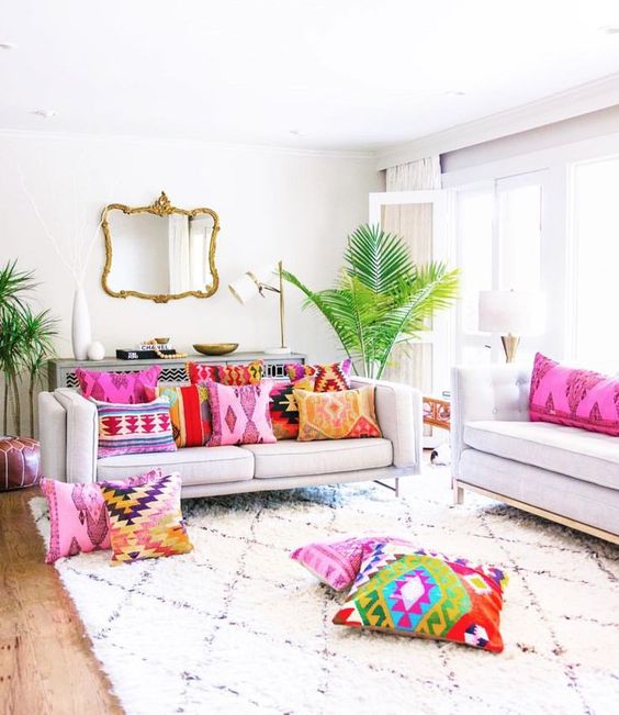 a neutral living room infused with bold printed pillows and tropical plants in pots for a summer feel