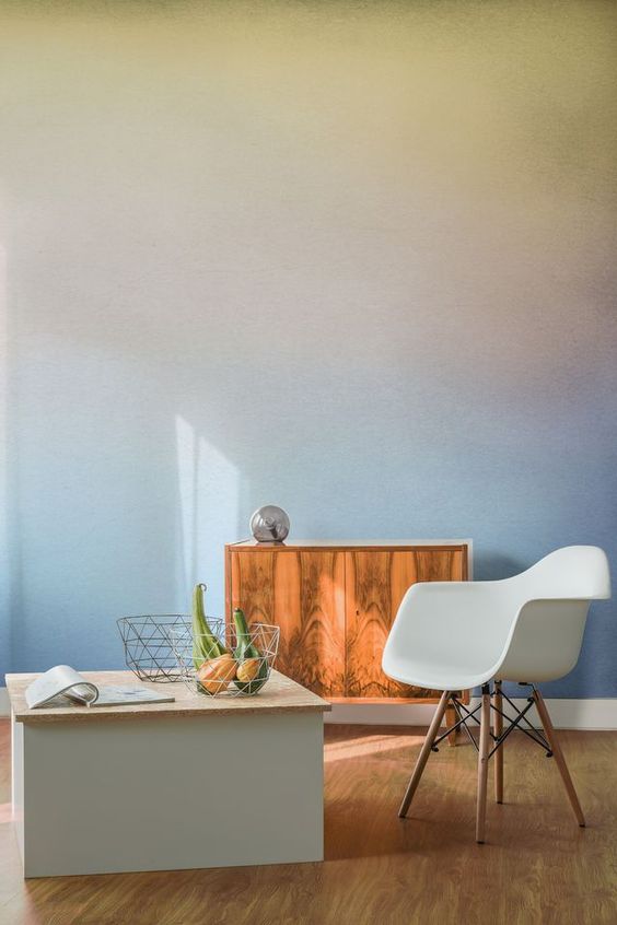 a pretty space with a soft-colored gradient wall, a stained cabinet, a white chair and a storage coffee table is lovely