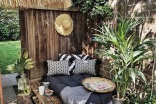 a simple boho bedroom nook with a pallet bed with pillows, potted greenery around located so that the sun didn’t get it