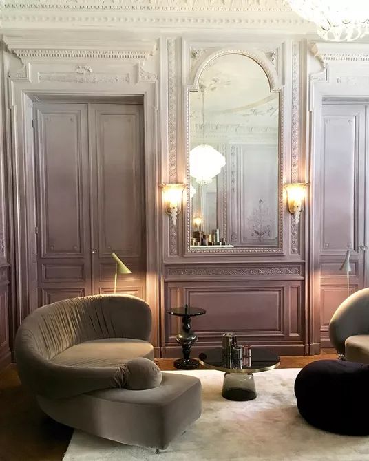 a sophisticated vintage living room with ombre lilac walls and doors, taupe and black seating furniture and coffee tables