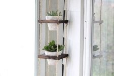 a vertical plant hanger of stained wood, twine and whitewashed planters is a lovely idea not only for a balcony but also for any other room