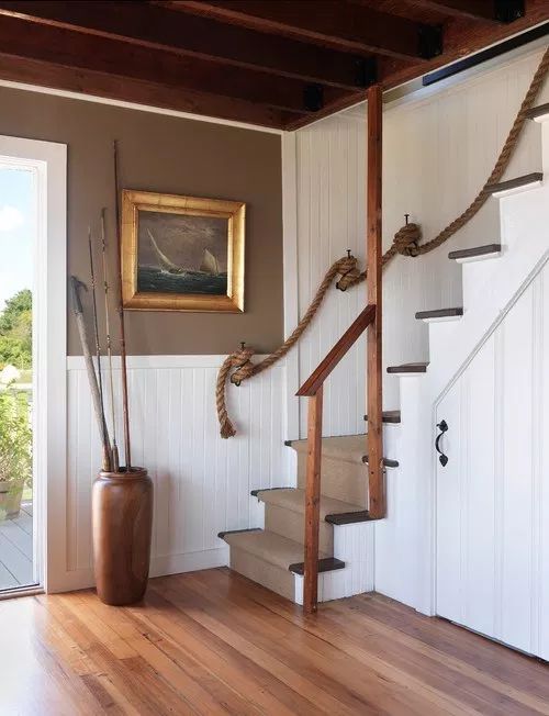 a very simple coastal staircase with a neutral carpet and rope railing is a stylish solution for a realxed beach house