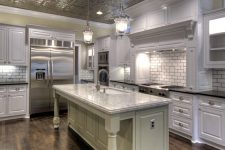a vintage neutral kitchen with a tin tile ceiling, white shaker cabinetry, a white tile backsplash and a tan kitchen island