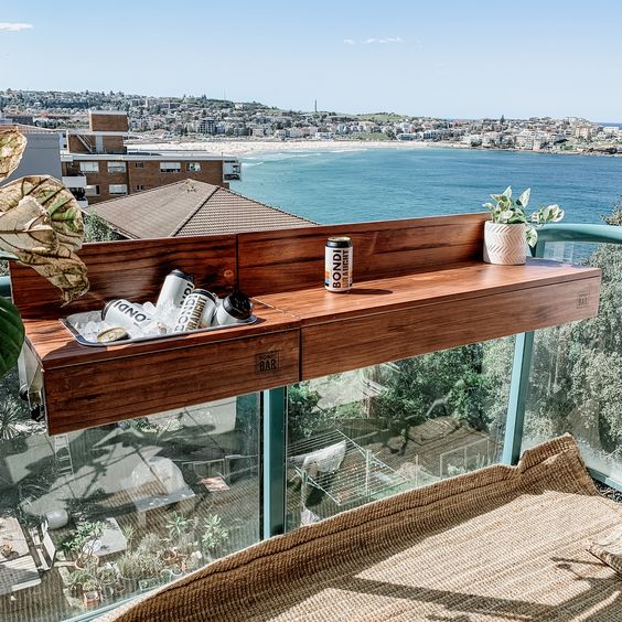 a wooden balcony bar table hanging on the railing is a lovely idea for a modern tiny outdoor space, it provides you with storage space