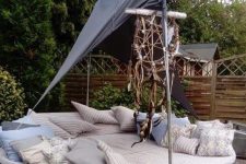 an old trampoline transformed into a large round bed with a canopy and lots of pillows looks amazing