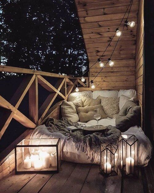 an outdoor bedroom on a blacony, with lights, lots of pillows, candle lanterns is utterly romantic and welcoming