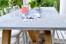 an outdoor dining table of wood and concrete and metal and wood chairs are a great setup for dining outdoors