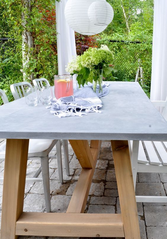 an outdoor dining table of wood and concrete and metal and wood chairs are a great setup for dining outdoors