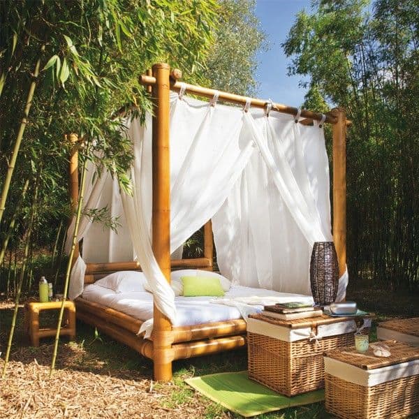 an outdoor tropical bedroom of bamboo, with canopies, woven chests for storage and a candle lantern is amazing