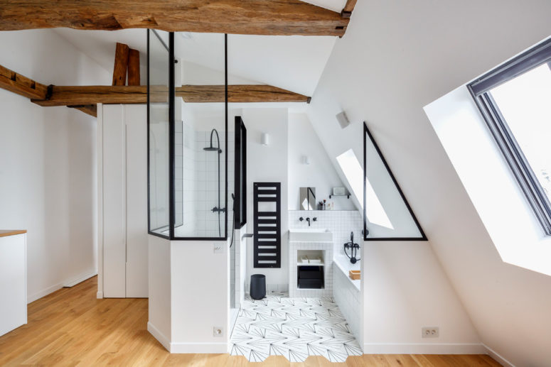 a chic white attic bathroom with black framing for more drama and wooden beams flooded with light  (Hopfab)