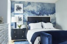 a bold navy bedroom design with a watercolor accent wall