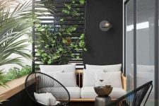 a chic balcony with black walls, a neutral sofa, black chairs and a tiny table plus lots of greenery