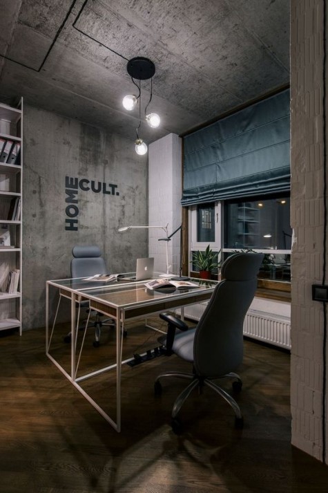 a contemporary meets industrial home office with concrete walls and a ceiling, leather chairs, sleek desks with glass tabletops and a metal shelving unit