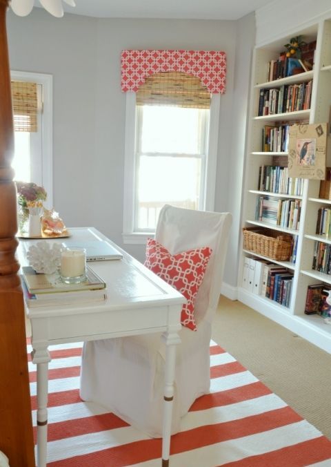 a cool home office with dove grey walls, striped textiles, elegant white furniture is a chic space to work in