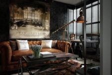 a dark industrial room with a leather sofa, a wood and metal table, a vintage metal pendant lamp and a fur rug