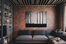 a laconic industrial living room done with a catchy ceiling, brick walls and a large scale tile floor