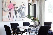 a luxurious dining room with a glass dining table, elegant black chairs, a chic chandelier and printed curtains, a bold graffiti artwork