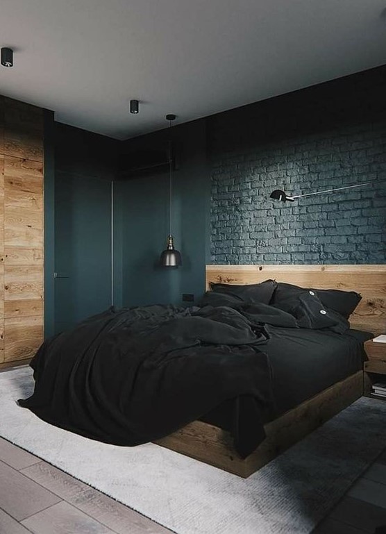 a modern industrial farmhouse bedroom with black brick walls, a neutral wooden bed and wall and dark lamps