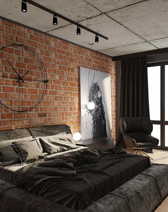 a modern industrial space ith brick walls, a concrete ceiling, an upholstered bed, a statement artwork and unique industrial clock