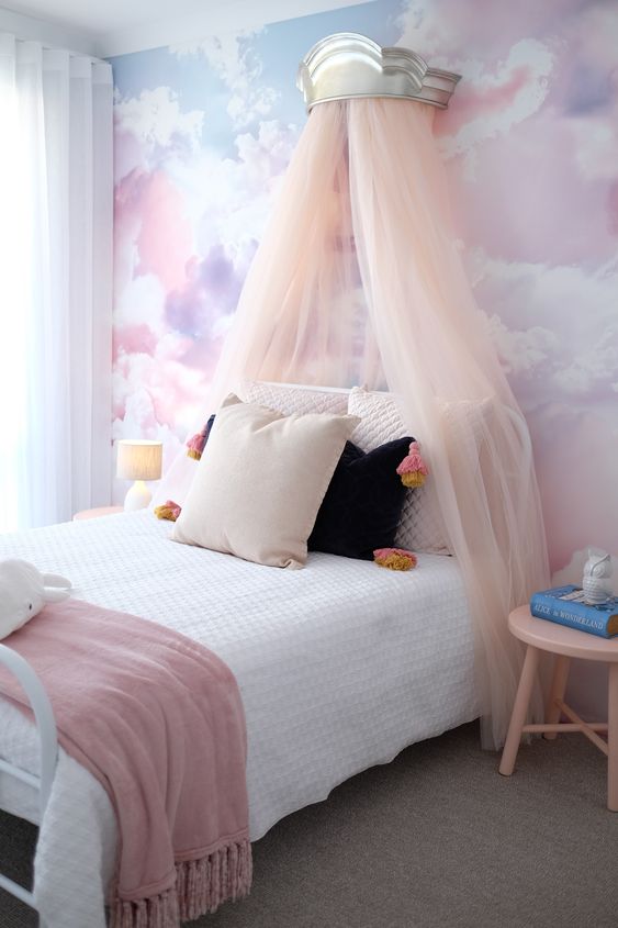 a lovely girl's bedroom with a watercolor accent wall